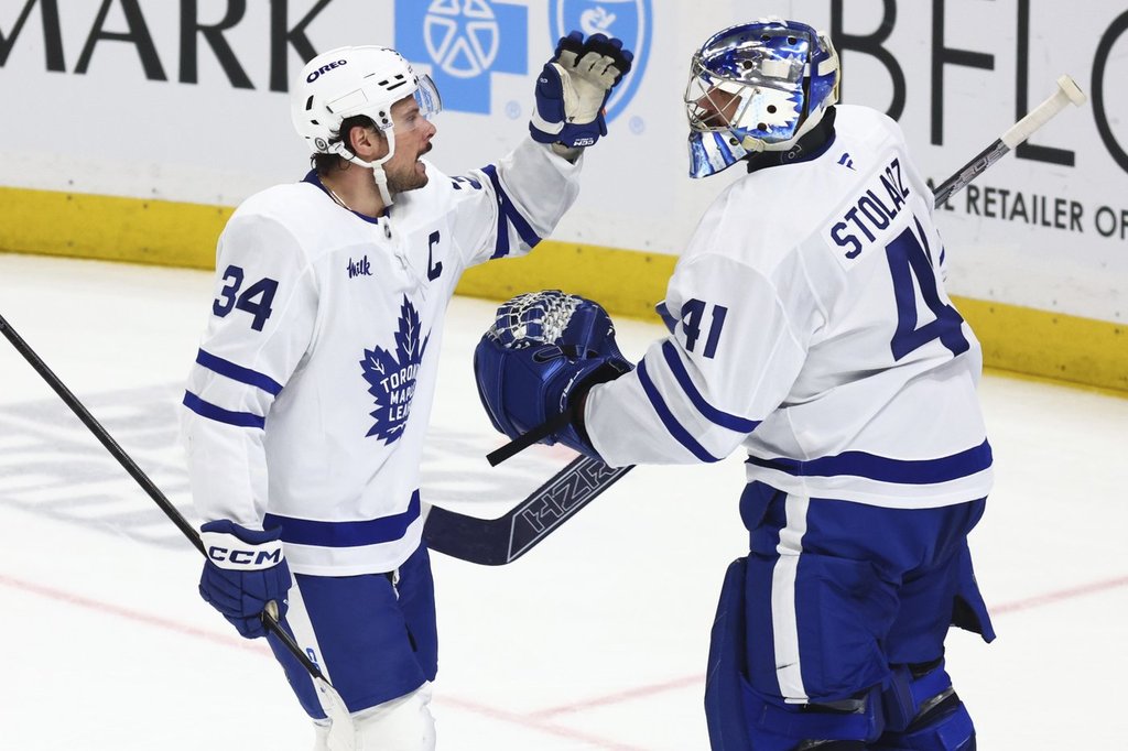 Toronto Maple Leafs center Auston Matthews (34) celebrates his goal with goaltender Anthony Stolarz (41) during the third period of an NHL hockey game against the Buffalo Sabres, Tuesday, April 15, 2025, in Buffalo, N.Y. (AP Photo/Jeffrey T. Barnes).