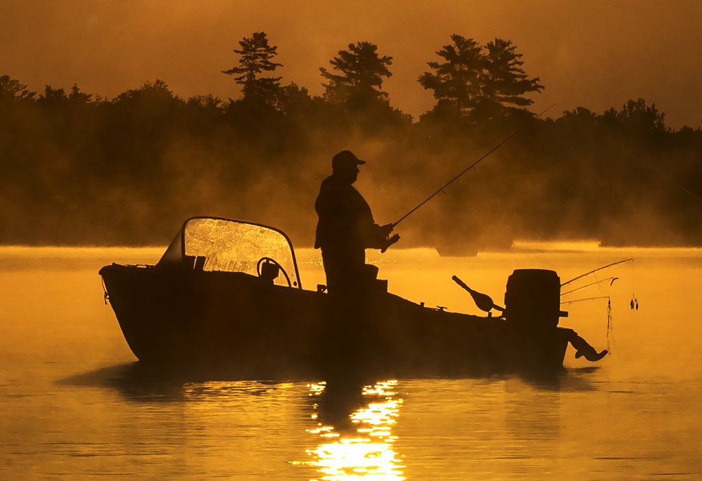 A man fishes in early morning on Little Bald Lake in central Ontario on Sunday, July 17, 2022. More than 50 years after it was last used in New Brunswick, new research shows the insecticide DDT is still found in "alarming" rates in trout, potentially posing a danger to other animals and humans that eat the fish. THE CANADIAN PRESS/Fred Thornhill.