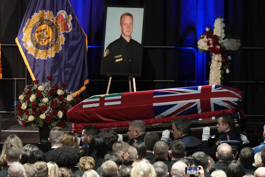 Pallbearers carry the casket of OPP Const. Grzegorz (Greg) Pierzchala after his funeral service at the Sadlon Arena in Barrie, Ontario.