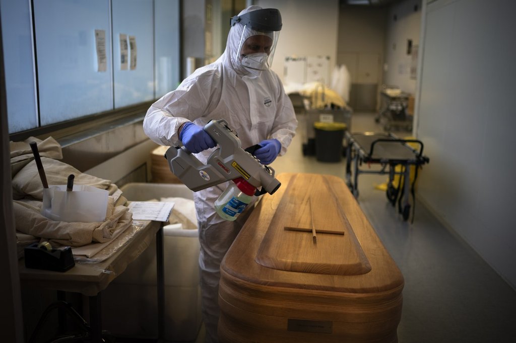 FILE - A mortuary worker disinfests a coffin carrying the body of a person who died of COVID-19 ahead of a funeral at Memora mortuary in Girona, Spain, Thursday, Feb. 4, 2021. (AP Photo/Emilio Morenatti, File)