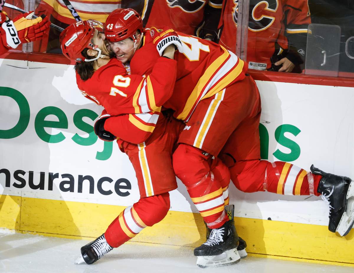 Calgary Flames' Ryan Lomberg (70) celebrates his goal with teammate Adam Klapka (43) during third period NHL hockey action against the Minnesota Wild in Calgary on Friday, April 11, 2025.
