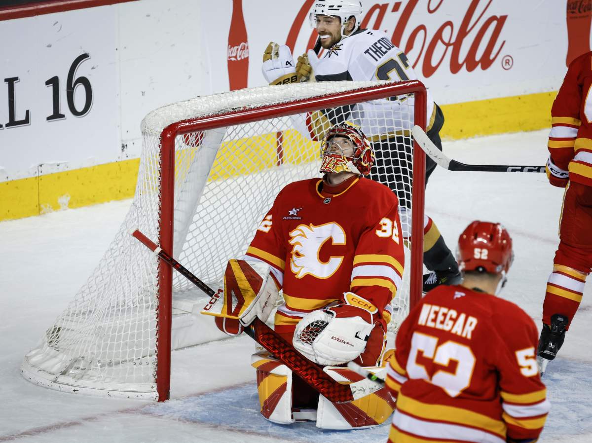 Vegas Golden Knights' Shea Theodore, top, celebrates his team's winning goal as Calgary Flames goalie Dustin Wolf reacts during overtime  NHL hockey action in Calgary on Saturday, April 5, 2025.