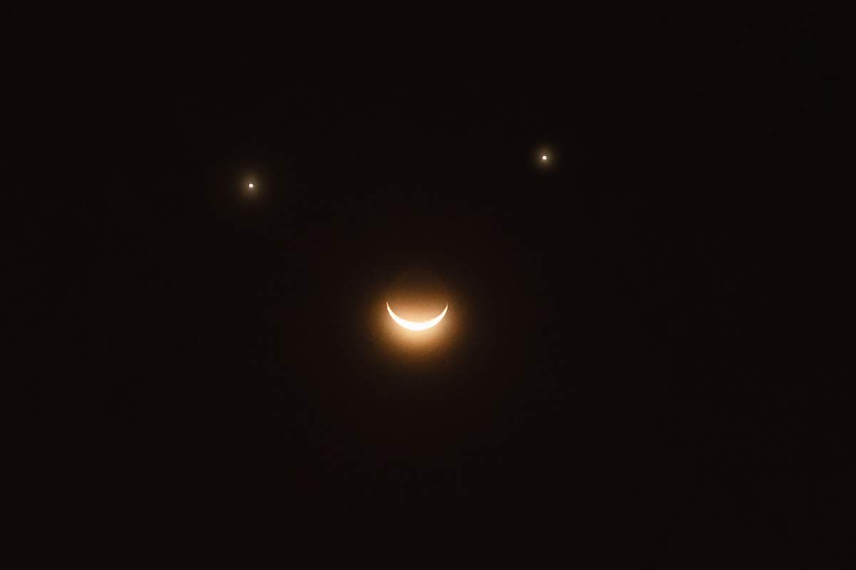Saturn, Venus and the moon are lining up to make a cosmic smiley face, similar to the one seen in this stock image.