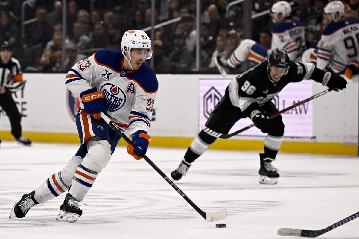 Edmonton Oilers centre Ryan Nugent-Hopkins (93) controls the puck with defence from Los Angeles Kings left wing Andrei Kuzmenko (96) during the first period of an NHL hockey game in Los Angeles, Saturday, April 5, 2025.