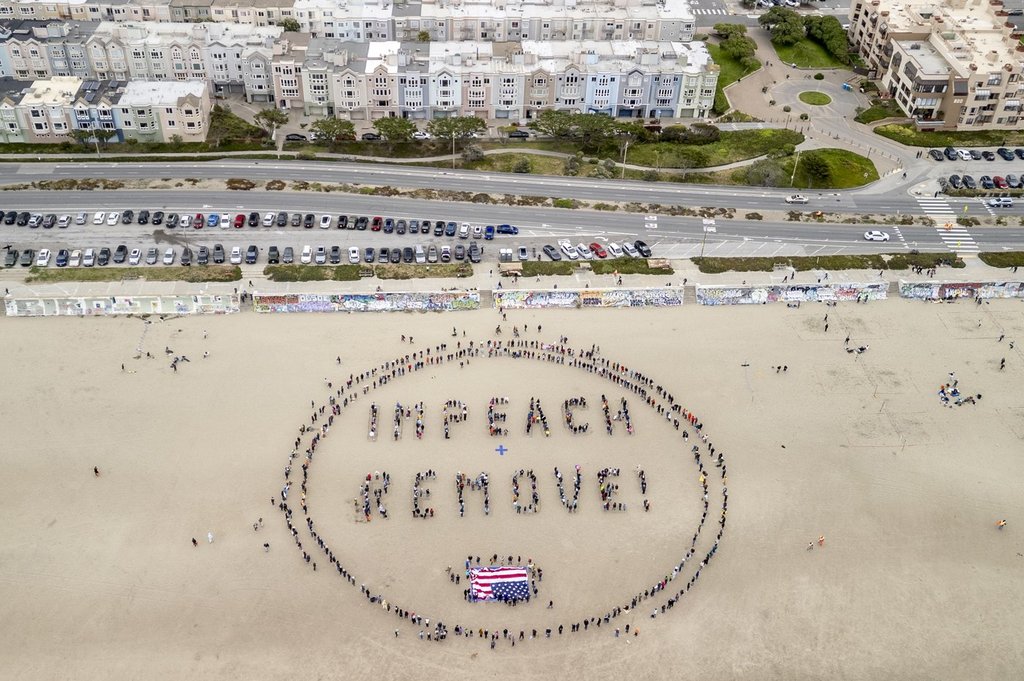 Protesters form a "Impeach & Remove" human banner on Ocean Beach during a protest against U.S. President Donald Trump, in San Francisco, Saturday, April 19, 2025.