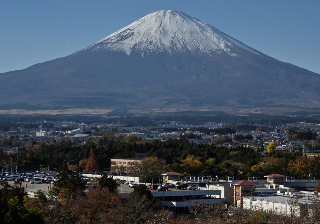 A file photo taken on November 28, 2024 shows Mount Fuji pictured behind the city of Gotemba, Shizuoka prefecture, some 100 kms southwest of Tokyo.