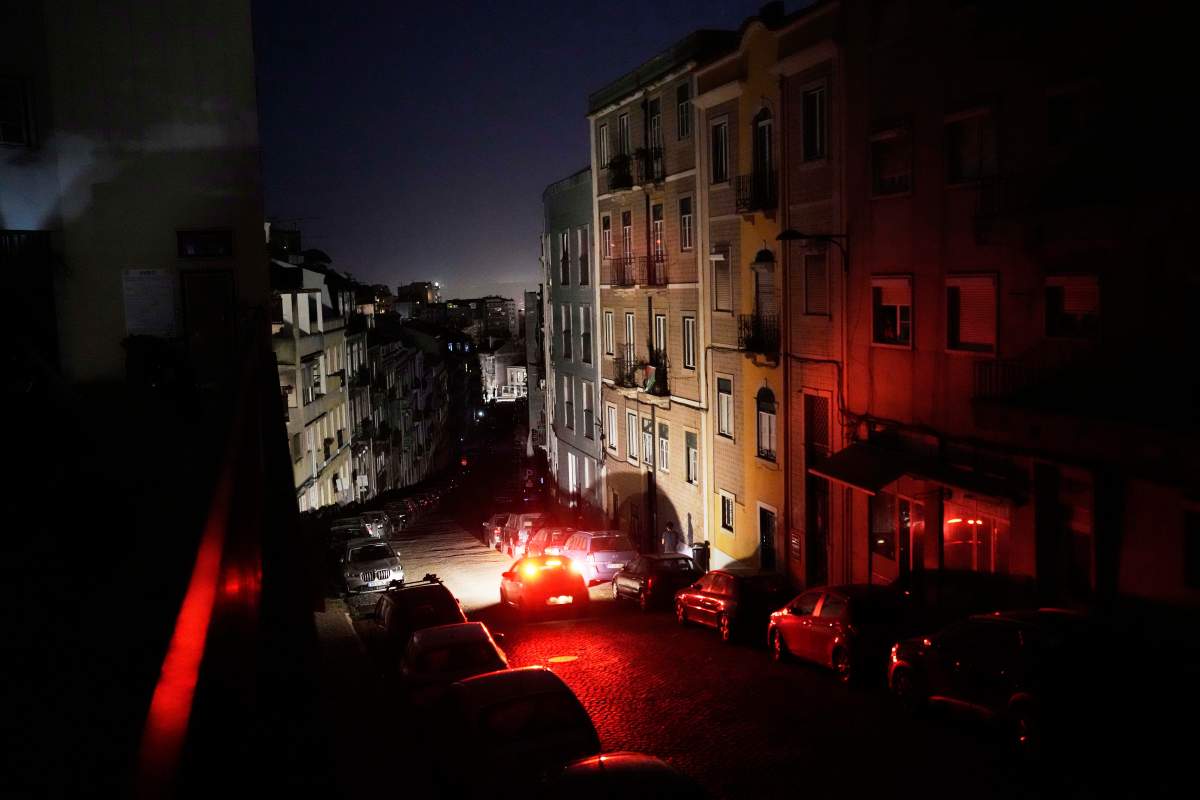 A car drives down an unlit street in Lisbon, during a nationwide power outage, Monday night, April 28, 2025.