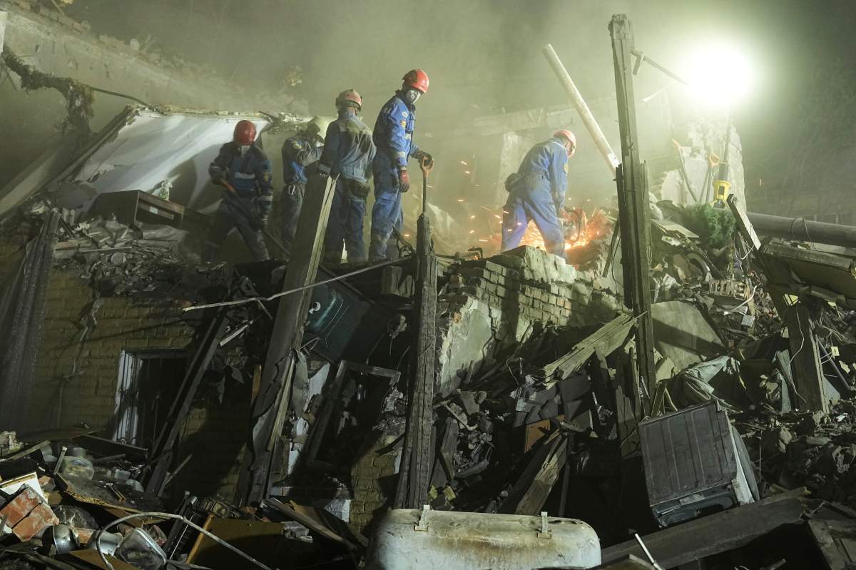 Ukrainian searchers clear the rubble after a Russian ballistic missile attack in Kyiv, Ukraine, early Thursday, April 24, 2025. (AP Photo/Efrem Lukatsky)