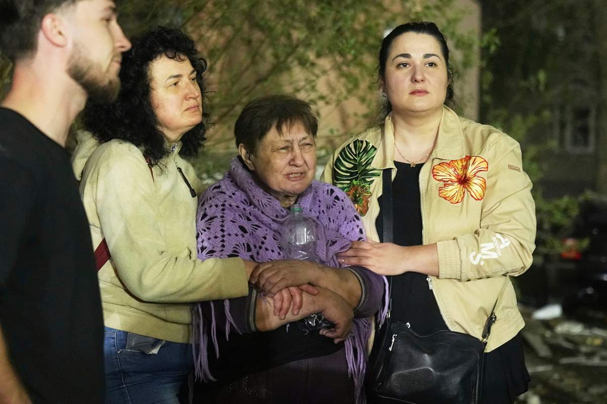 Local residents react at the site of an apartment building hit by a Russian ballistic missile attack in Kyiv, Ukraine, early Thursday, April 24, 2025. (AP Photo/Efrem Lukatsky)