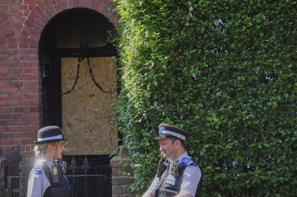 Police Community Support Officers stand near the fire damaged doorway of a house belonging to British Prime Minister Keir Starmer in Kentish Town in London, Tuesday, May 13, 2025. 