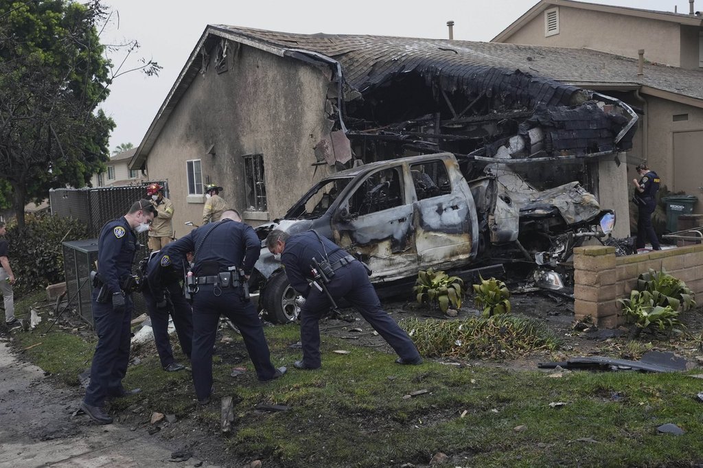 Authorities work the scene where a small plane crashed into a San Diego neighbourhood, setting several homes on fire and forcing evacuations along several blocks early Thursday, May 22, 2025.