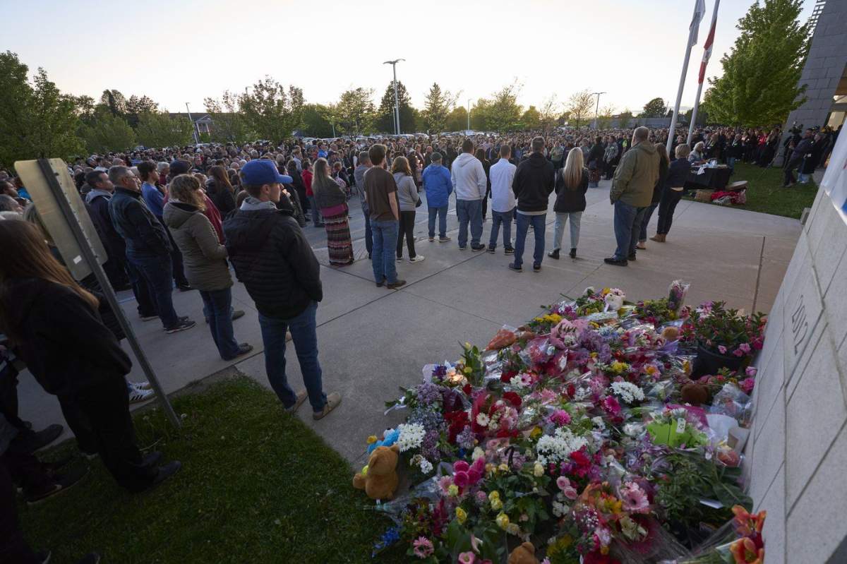 Hundreds gather in the parking lot of the Walkerton District Community School in Walkerton, Ont. for a vigil on Sunday, May 25, 2025. On Friday, four students and a teacher from the school were killed in a car accident on the way back from a softball tournament in Dorchester, Ontario.