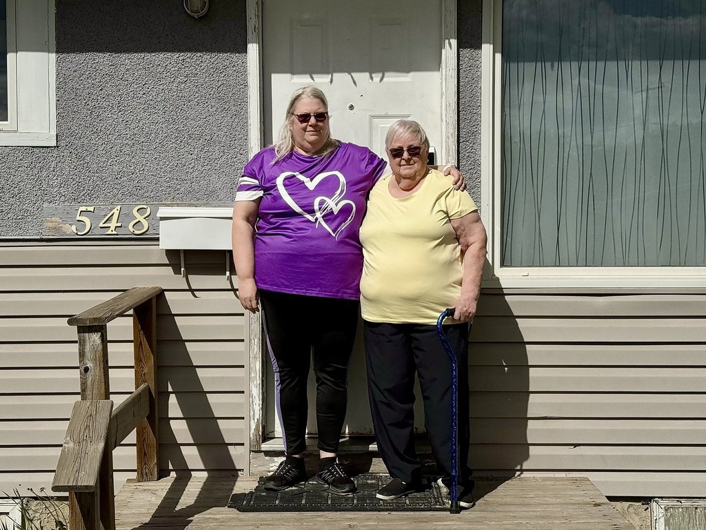 Kyara Moon, 59, and her mother Judy Frank, 78, stand outside their home next to their mailbox in Regina on Friday, May 23, 2025. Moon says they’re concerned about a report’s recommendation for Canada Post to end of door-to-door mail delivery for residential addresses. THE CANADIAN PRESS/Jeremy Simes