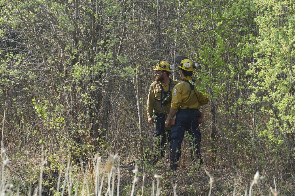 Members of the Manitoba Wildfire Program survey the land as fire crews continue to fight wildfires around Lac du Bonnet, Man., on Thurs. May 15, 2025. THE CANADIAN PRESS/David Lipnowski