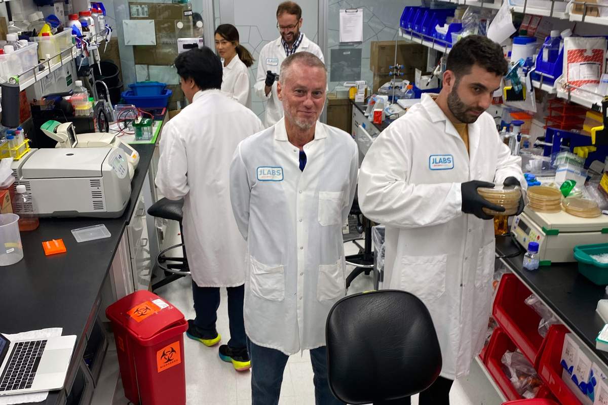 In this photo provided by Centivax, Tim Friede, center, stands in a lab in South San Francisco, Calif., in 2023, that is using his blood to prepare an antivenom to the bites of various snakes. (Centivax via AP)