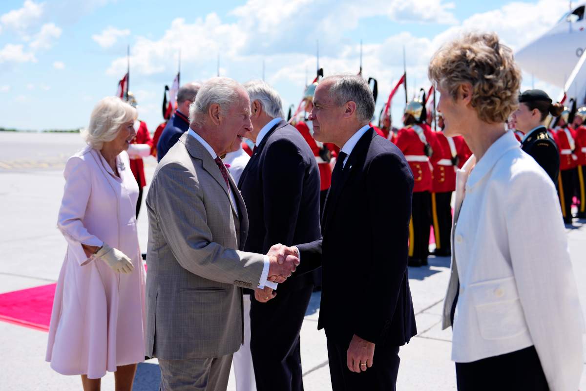 Prime Minister Mark Carney greets King Charles as he and Queen Camilla arrive at the Ottawa International Airport in Ottawa for a royal visit on May 26, 2025.