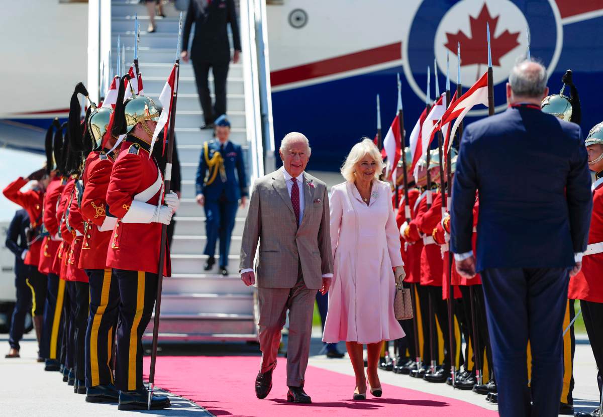 King Charles and Queen Camilla pass an honour guard from the Royal Canadian Dragoons as they arrive at the Ottawa International Airport in Ottawa for a royal visit, on Monday, May 26, 2025. THE CANADIAN PRESS/Justin Tang