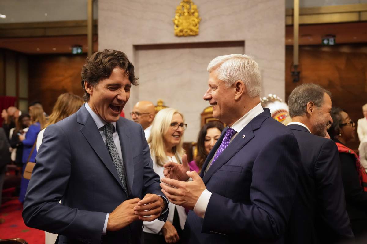 Former prime ministers Justin Trudeau, left, and Stephen Harper share a laugh ahead of King Charles delivering the speech from the throne in the Senate in Ottawa on Tuesday, May 27, 2025. THE CANADIAN PRESS/Chris Young