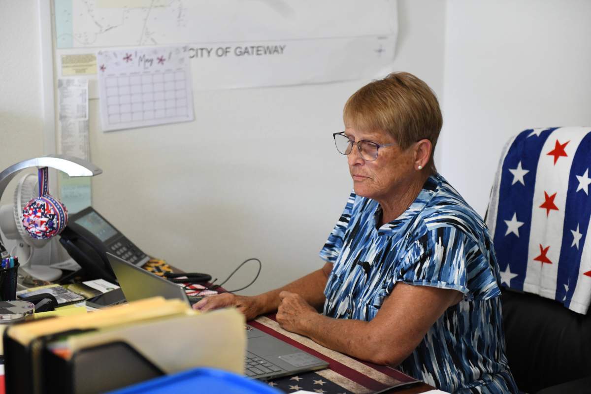 Cheryl Tillman, mayor of Gateway, Ark., and sister of James Appleton, who was fatally shot in 2017, works on her laptop at Town Hall on May 28, 2025. Grant Hardin, who briefly served as police chief, pleaded guilty to first-degree murder.