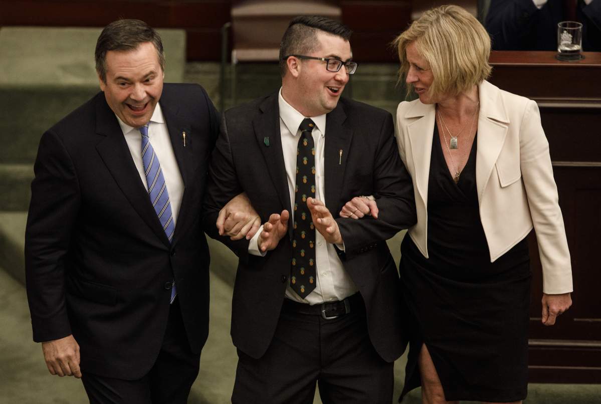 In tradition, newly-elected speaker of the house Nathan Cooper is dragged to the chair by Alberta Premier Jason Kenney and NDP Leader Rachel Notley, after being voted in, in Edmonton on Tuesday, May 21, 2019.