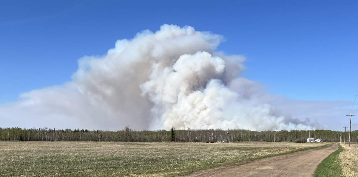 The RCMP said on Friday that they have arrested a man accused of tampering with sprinklers being used to protect homes in the evaucation zone near an out of control wildfire, burning north of Edmonton. The fire, near the Redwater Lake Provincial Recreation area, is seen in this photo on Tuesday.