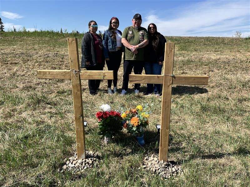 The family (from left to right: Kellie Kara Konchinew, Konstance Kate Hurt, Lawrence Junior Konchinew, Kari Lynn Konchinew) of two people killed in a crash in Leduc County on April 2, 2025 stand in front of a pair of memorials near the scene of the crash on May 13, 2025.