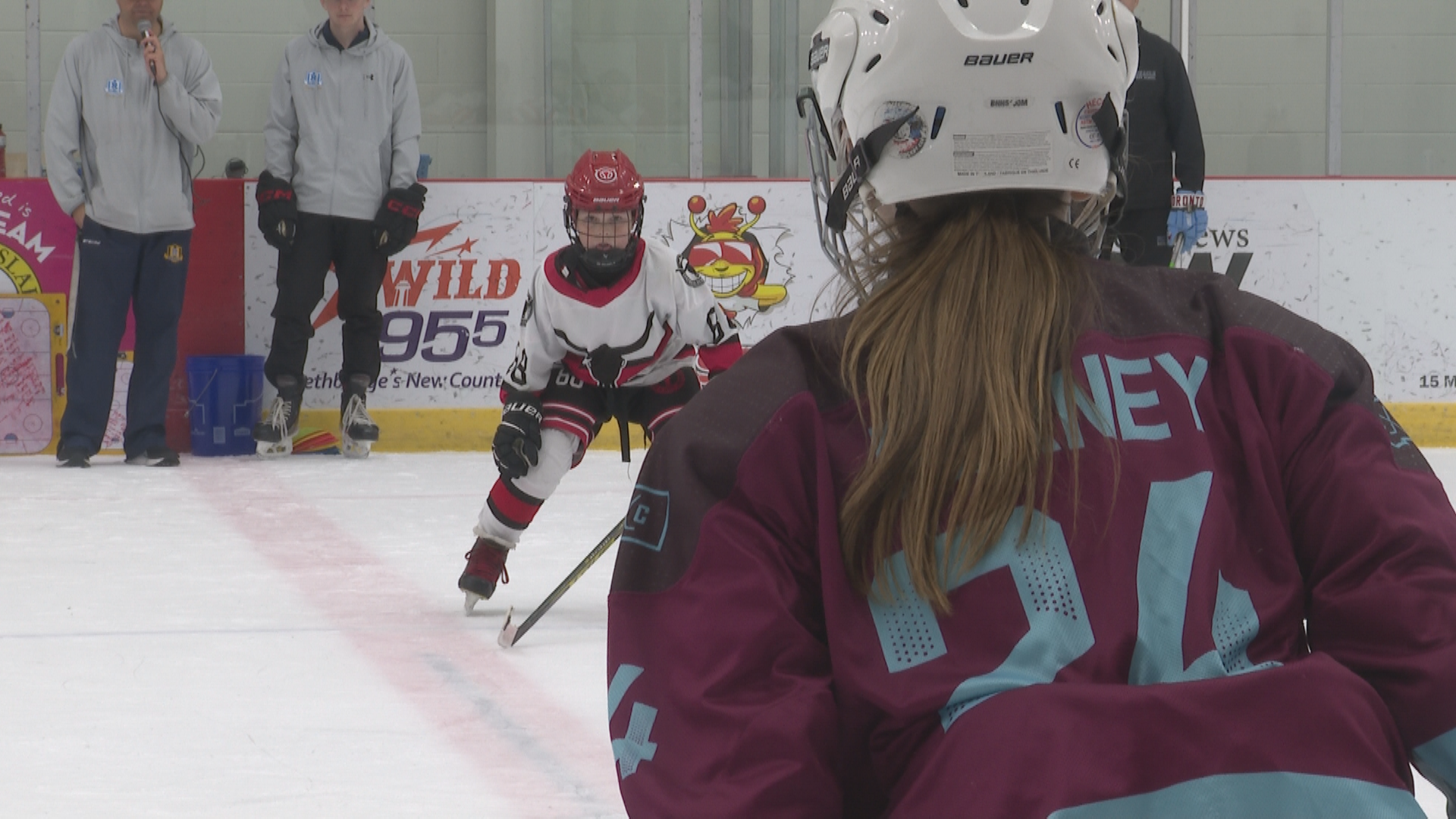 Two young hockey athletes facing off in a race.