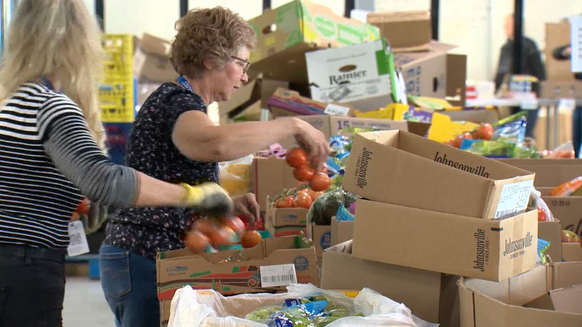 Volunteers at the Calgary Food Bank are seen packing food hampers. Last year, the organization said it handed out 173,354 emergency food hampers -- including 57,878 to clients from working households.