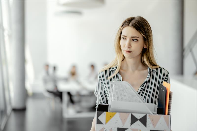 A businesswoman walks away from her colleagues after being fired.
