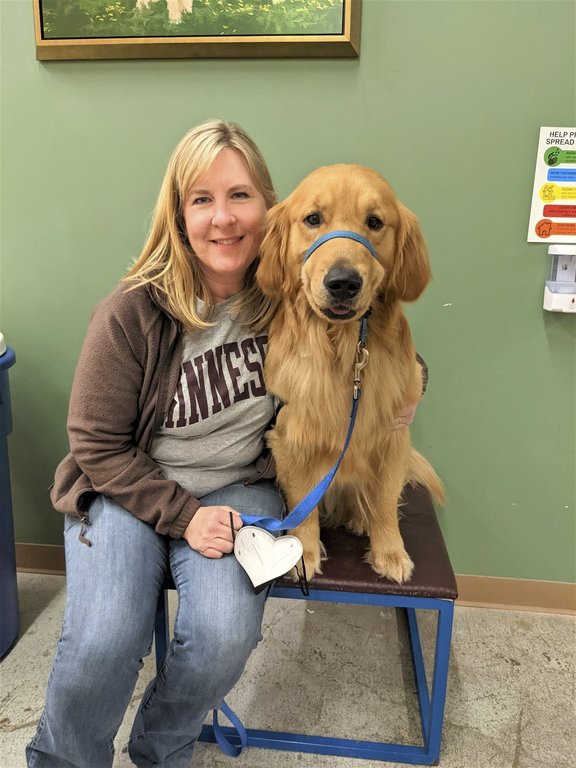 In this photo from 2022, provided by Helping Paws of Eden Prairie, Minn., state Rep. Melissa Hortman, DFL-Brooklyn Park, poses with Gilbert, a golden retriever trained to be a service dog but eventually adopted by the Hortman family, at a training facility in Hopkins, Minn.