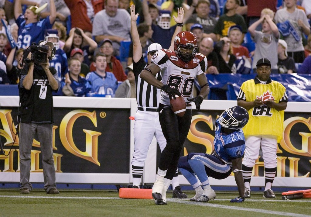 Calgary Stampeders receiver Jeremaine Copeland (left) scores the winning touchdown as Toronto Argonauts Lin-J Shell picks himself up off the turf during second half CFL action in Toronto, on Aug. 28, 2009.