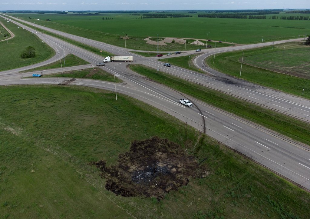 A scorched patch of ground where a bus carrying seniors ended up after colliding with a transport truck and is seen on the edge of the Trans-Canada Highway where it intersects with Hwy 5, near Carberry, Man., Friday, June 16, 2023. The crash killed 17 people.