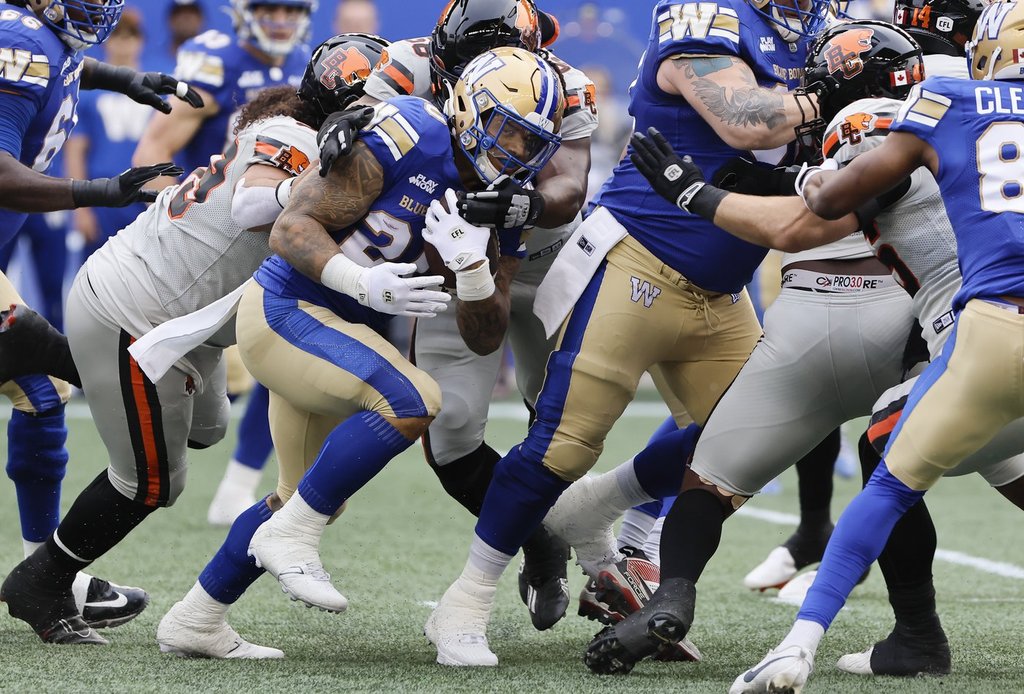Winnipeg Blue Bombers' Brady Oliveira (20) runs for the first down during first half CFL action against the BC Lions in Winnipeg Thursday, June 12, 2025. THE CANADIAN PRESS/John Woods.
