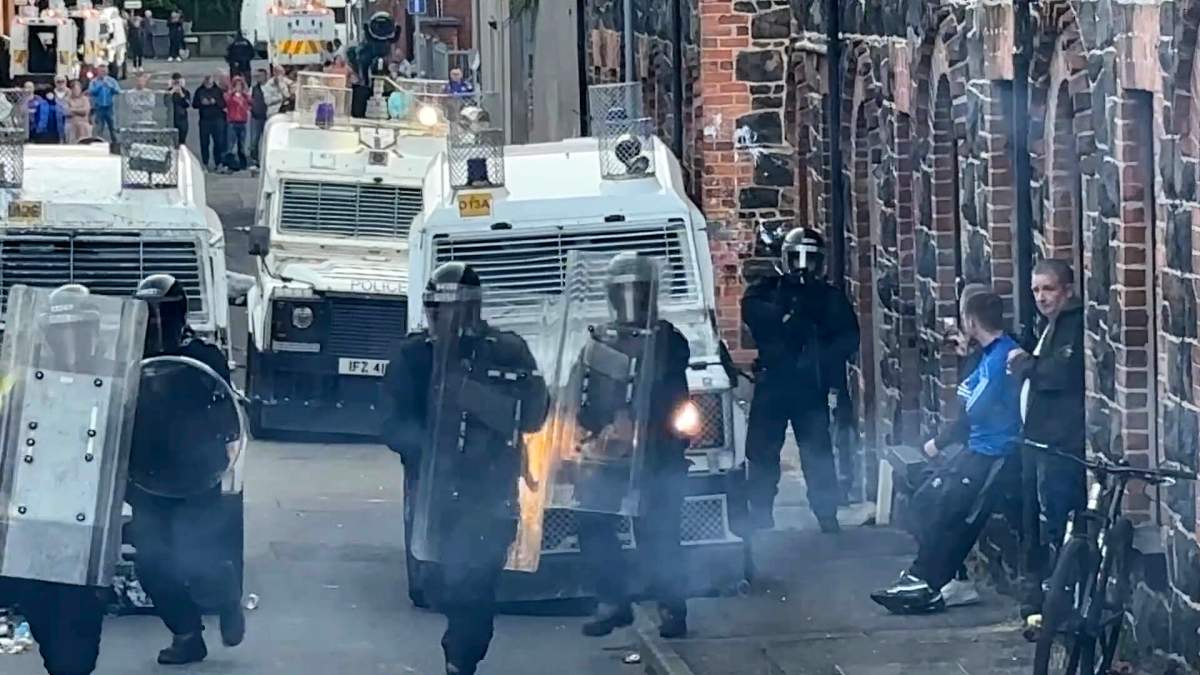 This image taken from PA Video shows riot police wearing armour and carrying shields at Clonavon Terrace, in Ballymena, Northern Ireland, as people take part in a protest over an alleged sexual assault in the Co Antrim town, Tuesday, June 10, 2025. (Niall Carson/PA via AP)