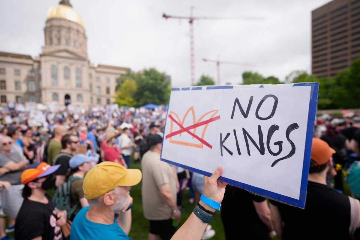 A demonstrator holds a sign during a “No Kings” protest, Saturday, June 14, 2025, in Atlanta. (AP Photo/Mike Stewart)