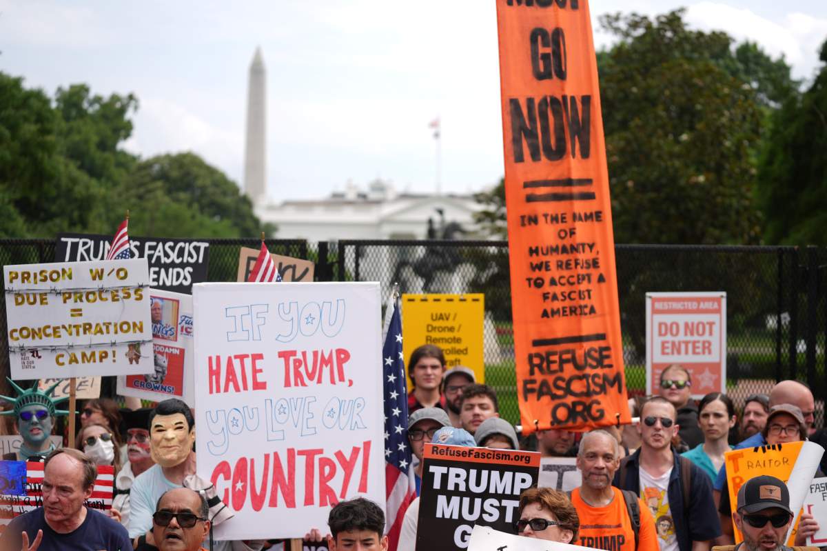 Demonstrators stand near the White House during a protest taking place on the day of a military parade commemorating the Army’s 250th anniversary, coinciding with President Donald Trump’s 79th birthday, Saturday, June 14, 2025, in Washington. (AP Photo/Evan Vucci)