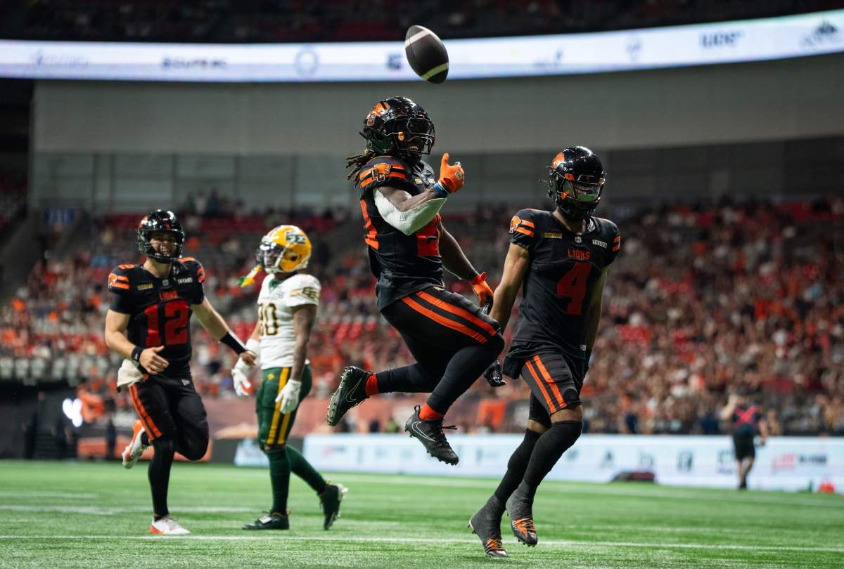 B.C. Lions' James Butler (20) celebrates scoring a touchdown against the Edmonton Elks as with Nathan Rourke (12) and Keon Hatcher Sr. (4) cheers during the second half of a CFL football game in Vancouver, on Saturday, June 7, 2025.