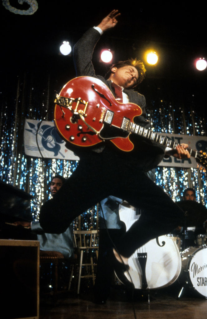Michael J Fox leaping in air with guitar in a scene from the film 'Back To The Future', 1985.