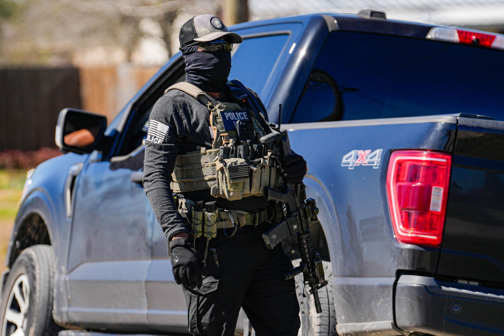 FILE: A Federal agent is photographed as ICE conduct raids on a local tire shop business in Colony Ridge, TX on Monday, Feb. 24, 2025.