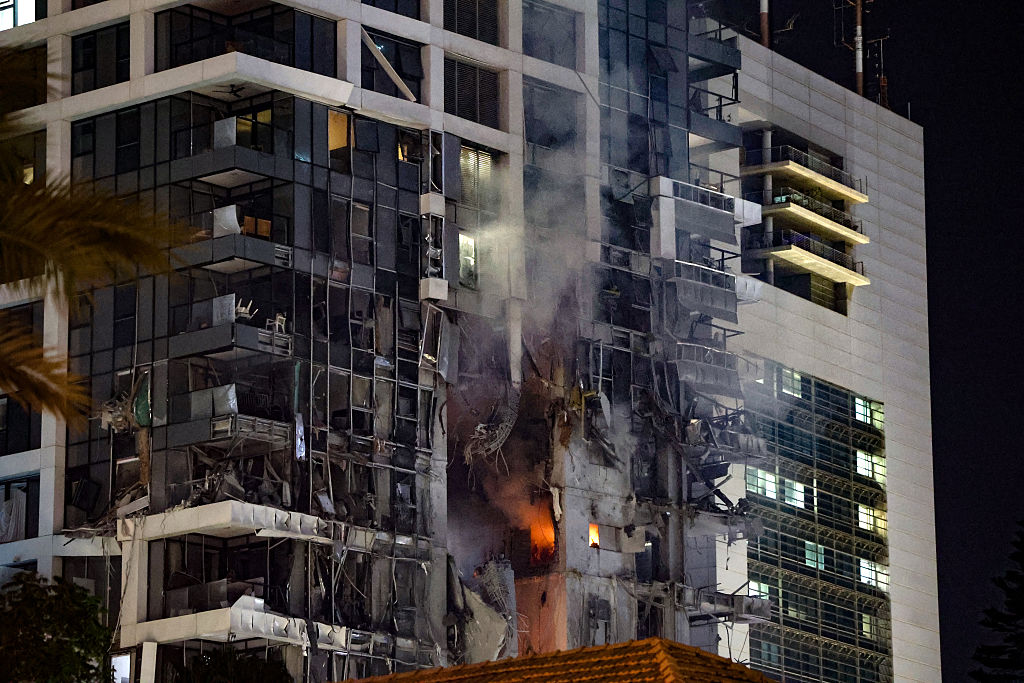 Fire and smoke rise from a building, reportedly hit by a missile fired from Iran, in central Tel Aviv on June 13, 2025.