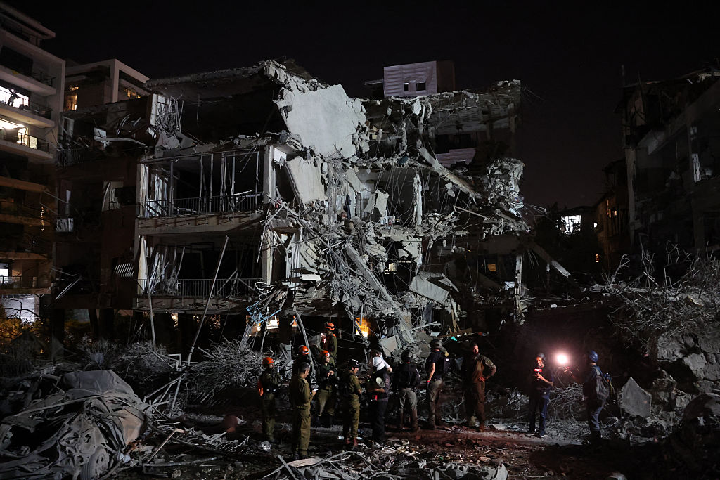 Israeli troops and first responders gather in front of a building hit by a missile fired from Iran, in Ramat Gan near Tel Aviv on June 13, 2025.