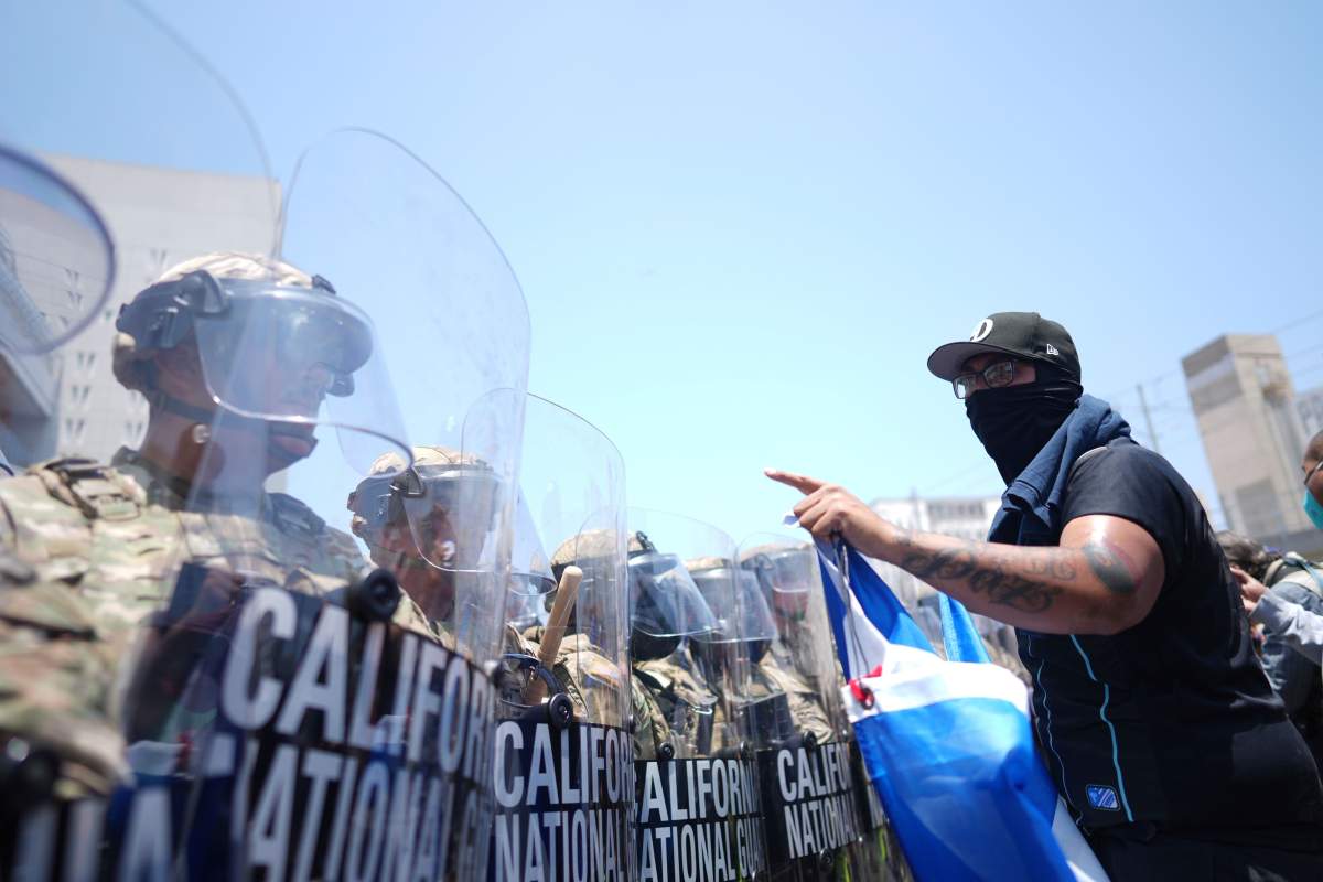 A protester confronts a line of U.S. National Guard in the metropolitan detention center of downtown Los Angeles, Sunday, June 8, 2025, following last night's immigration raid protest.
