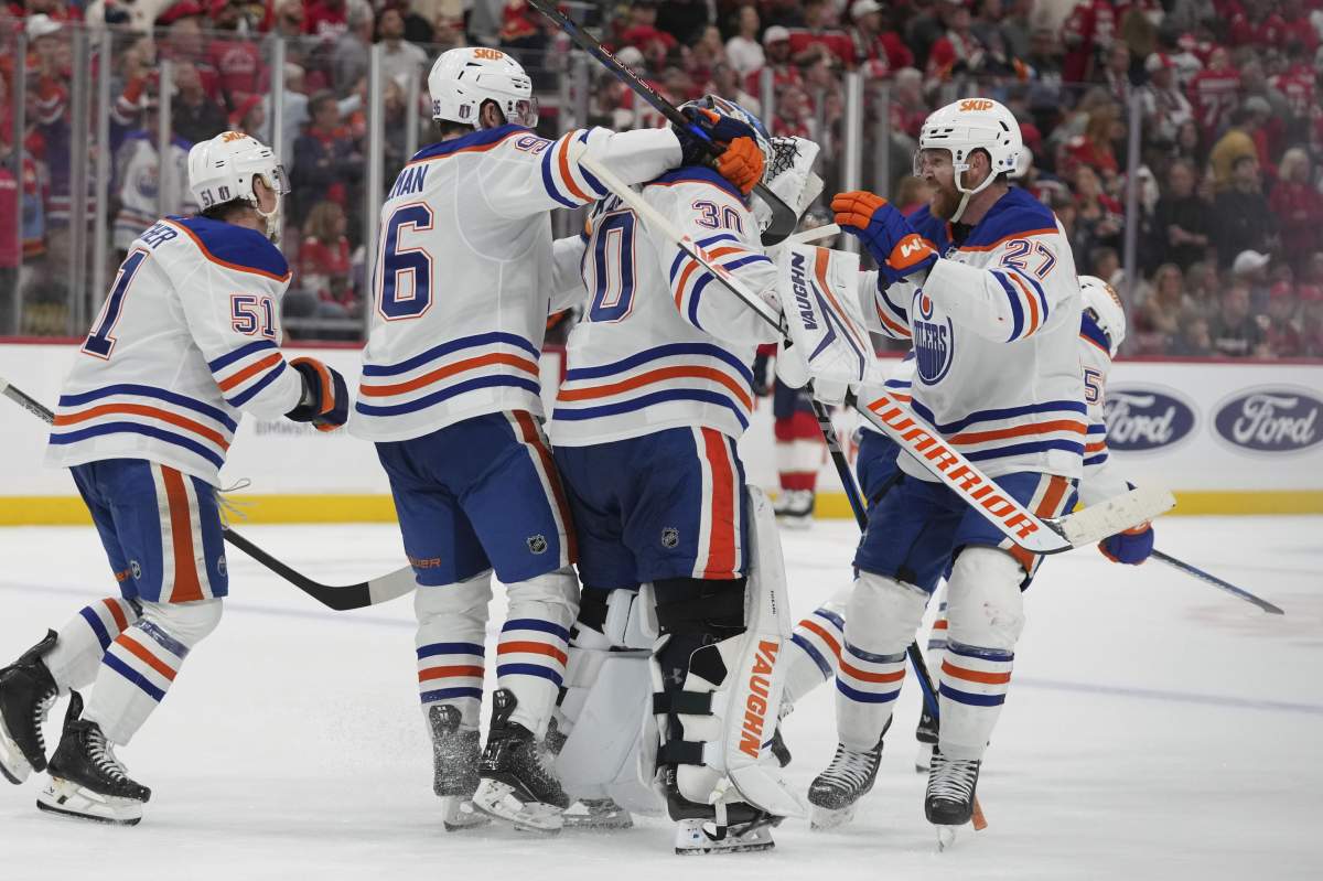 Edmonton Oilers players surround goaltender Calvin Pickard (30) after defeating the Florida Panthers in overtime during Game 4 of the NHL hockey Stanley Cup Final Thursday, June 12, 2025, in Sunrise, Fla.