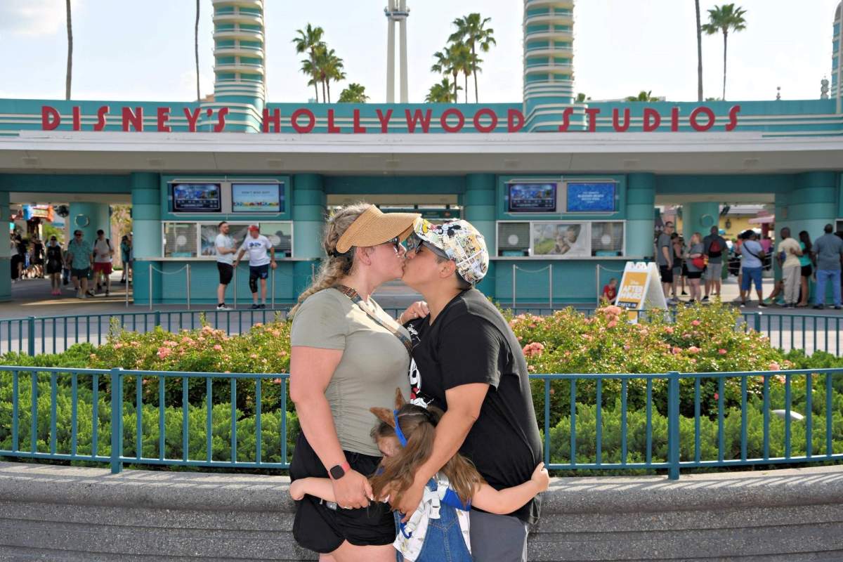 Miranda Sharp and her fiancé, Ashton Wilson, getting engaged at Disney World in the spring of 2025 while their daughter hugs them.