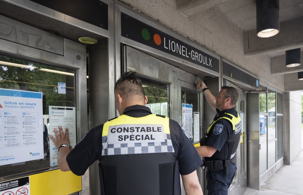 Special constables from the Société de transport de Montréal (STM) lock the doors to the metro station as metro and buses discontinue service due to the strike by maintenance workers in Montreal on Monday, June 9, 2025. THE CANADIAN PRESS/Christinne Muschi.