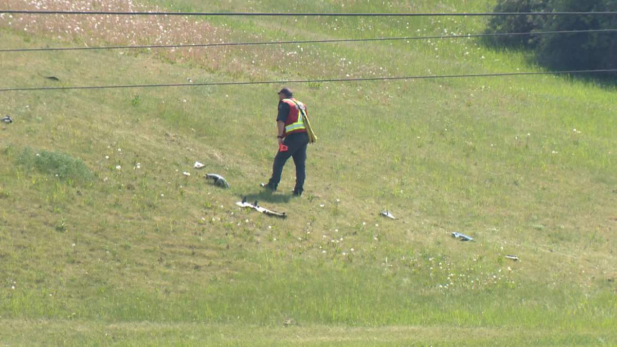 Investigators from the Calgary police collision reconstruction unit are seen examining some of the debris from a deadly motorcycle crash in northwest Calgary on Sunday afternoon.