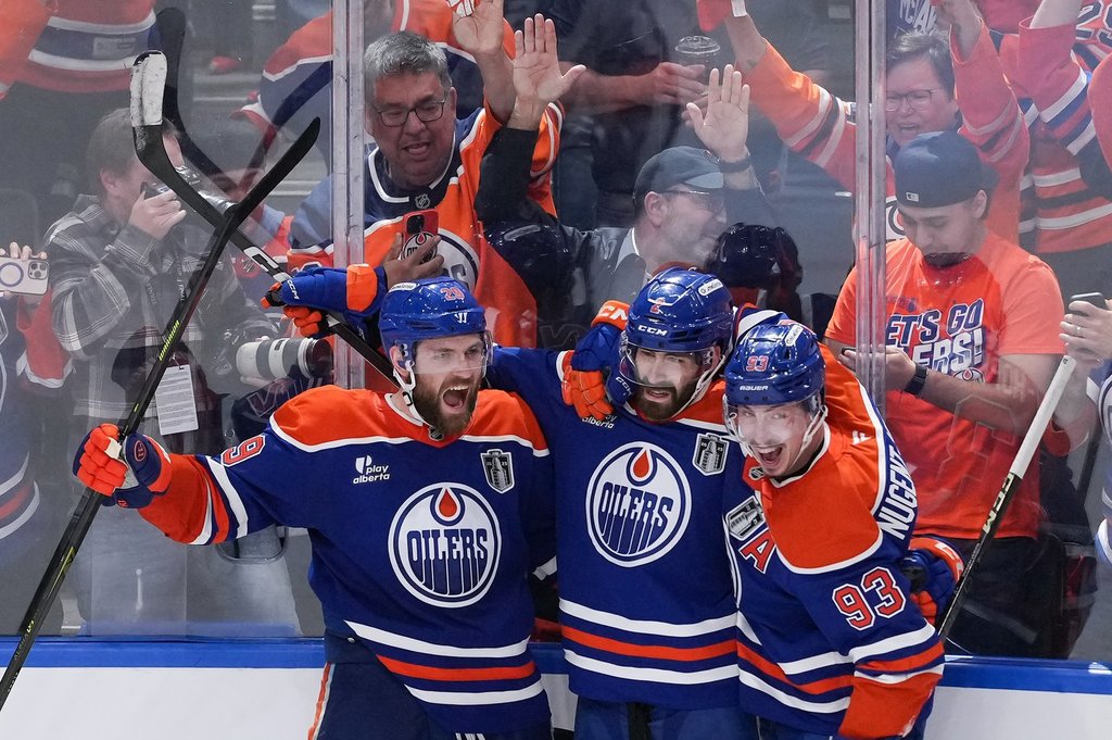Oilers centre Leon Draisaitl, from left to right, defenceman Evan Bouchard and forward Ryan Nugent-Hopkins celebrate Draisaitl's overtime winner in Game 1 of the NHL Stanley Cup final against the Florida Panthers in Edmonton on June 4, 2025.