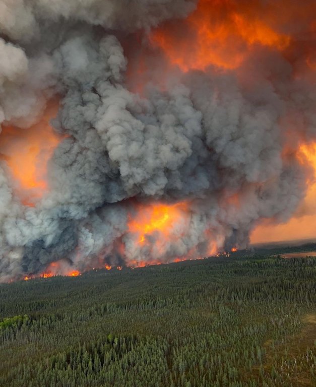 Flame and smoke fill the sky above a large wildfire burning in the La Ronge, Sask., area in an undated handout photo.