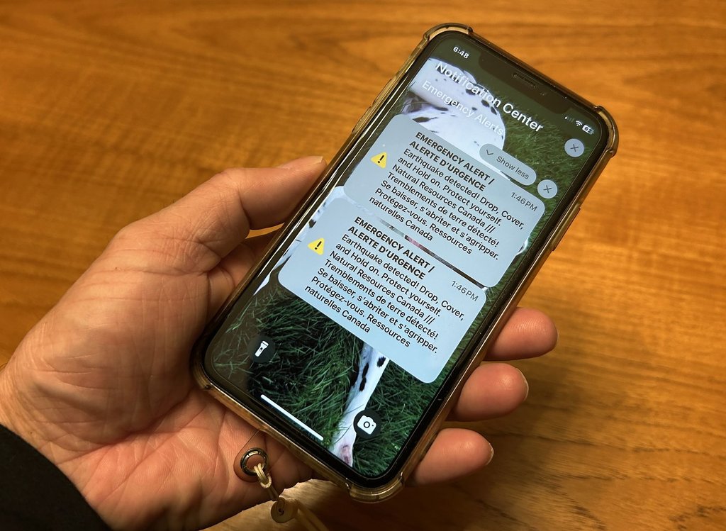 Canada's telecommunications regulator is launching a consultation aimed at improving the national public alerting system that is used to warn Canadians about emergency situations such as severe weather and other concerns to public safety. A person holds a cellphone showing an emergency alert in February when Southwestern British Columbia was rocked by an earthquake, which triggered some concern about the consistency and timing of alerts sent to residents. 