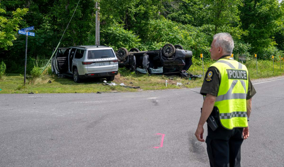 A Sûreté du Québec (SQ) police officer patrols a crash scene involving two vehicles in Hemmingford, Que., on Sunday, July 13, 2025.